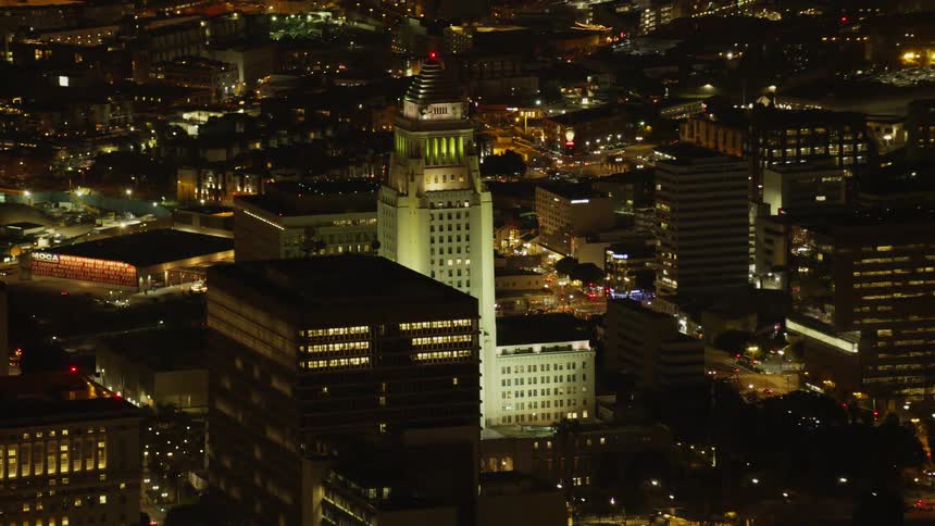 The tall building is brightly lit at night