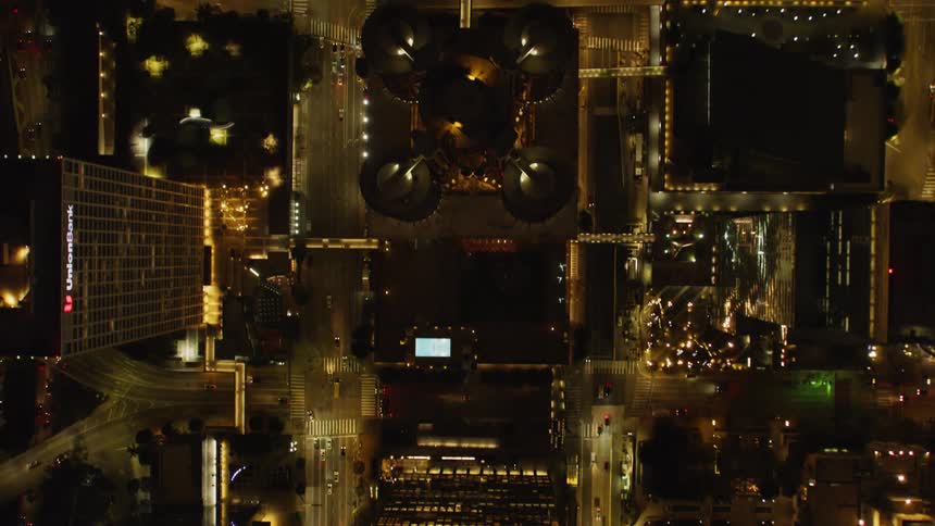 The rooftops are dark in the brightly lit city