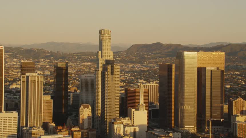 Skyscrapers stand in a city at sunset