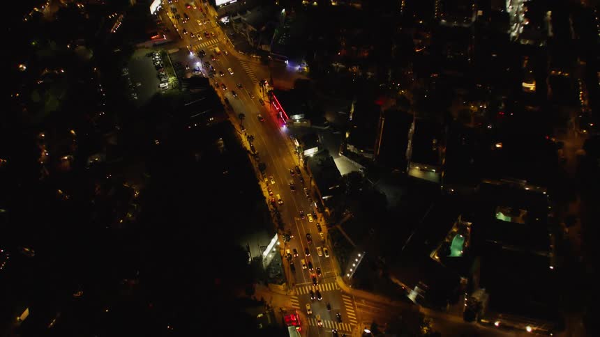 Cars drive on a city street at night