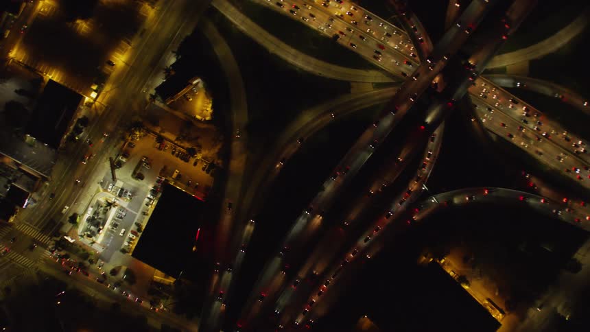 Cars drive on a city street at night