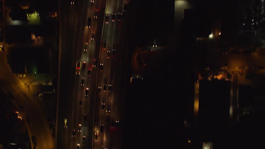Cars drive on a city street at night