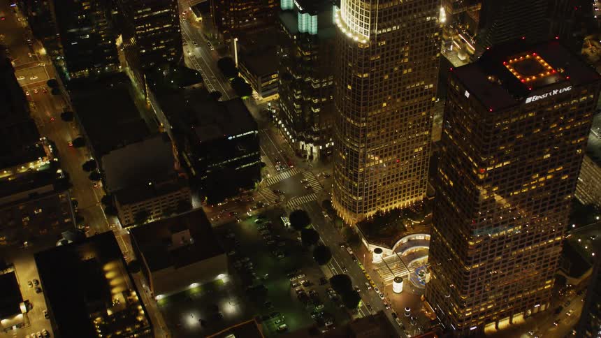 Large city with many tall buildings and roads lit up at night