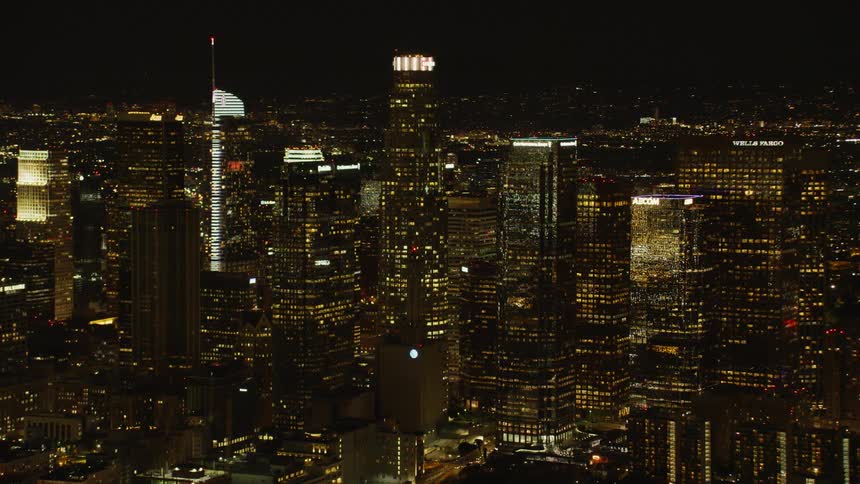 City skyscrapers illuminate the dark night sky