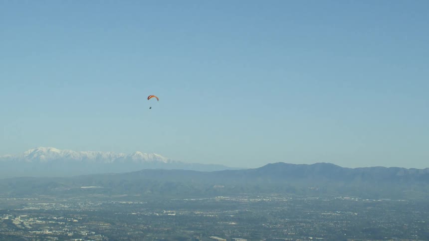 A parachuter glides in the sky
