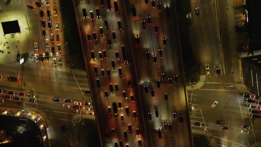 Cars drive on a city street at night