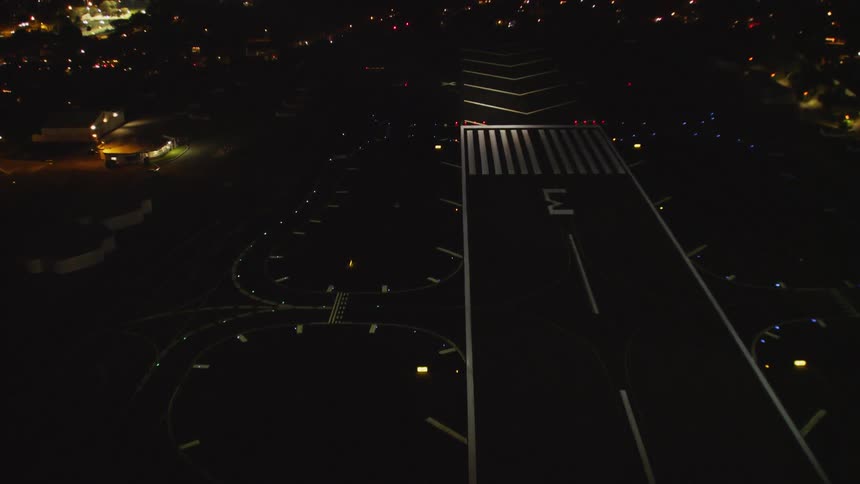 A light shines on an airport landing strip at night