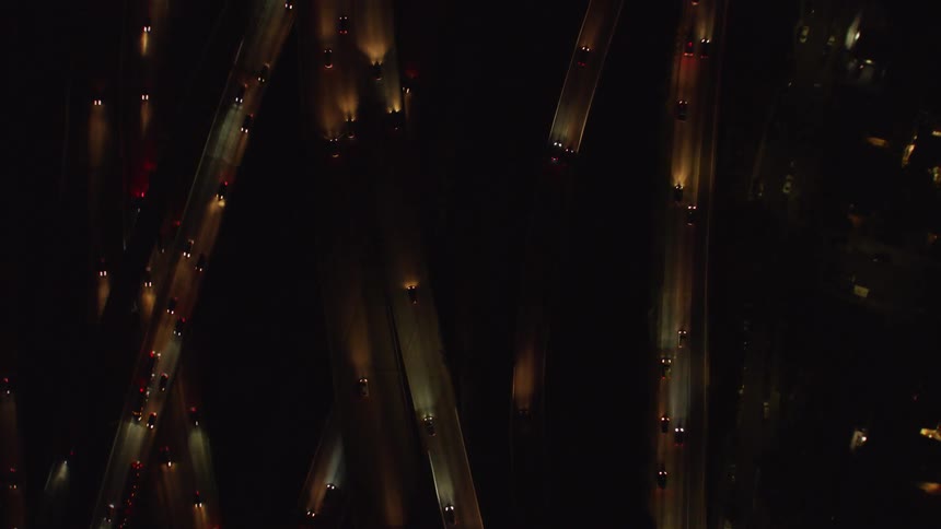 Cars drive on a city highway at night