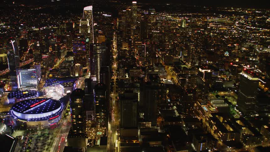 A sports arena is brightly illuminated at night