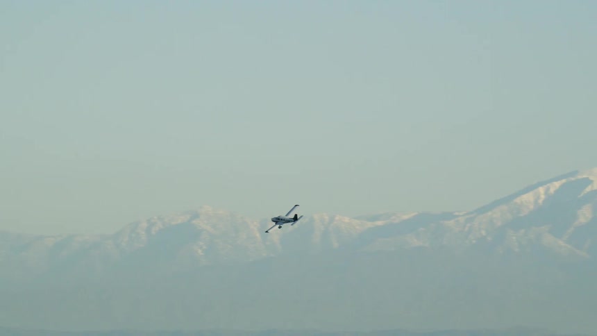 Airplane flies near snowy mountains