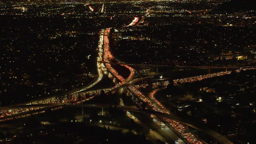 Cars drive on a city highway at night