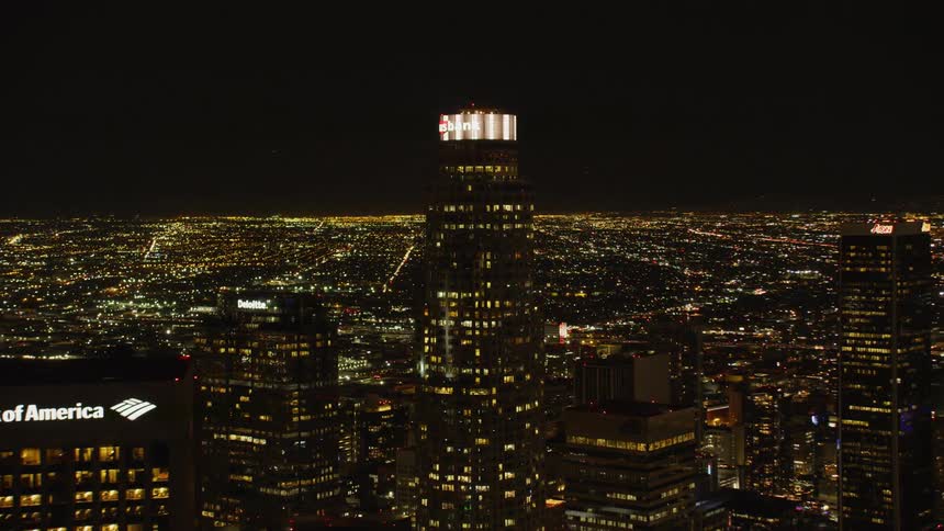 Tall skyscrapers sit under the night sky in a city