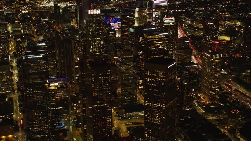 Large city with many skyscrapers lit up at night; Los Angeles