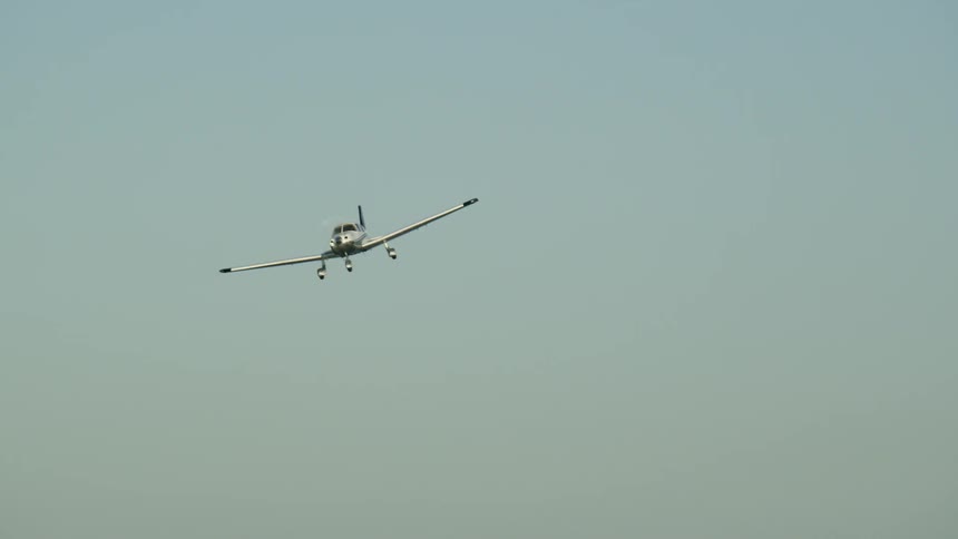 A single engine airplane is coming in for a landing on a sunny day