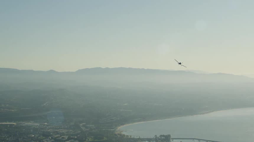 Airplane banks left as it flies over a lake