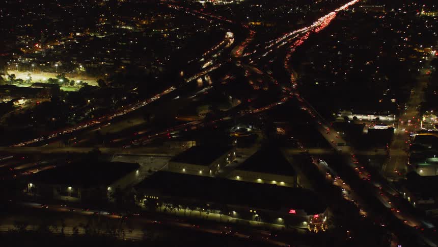 Cars drive on a city street at night