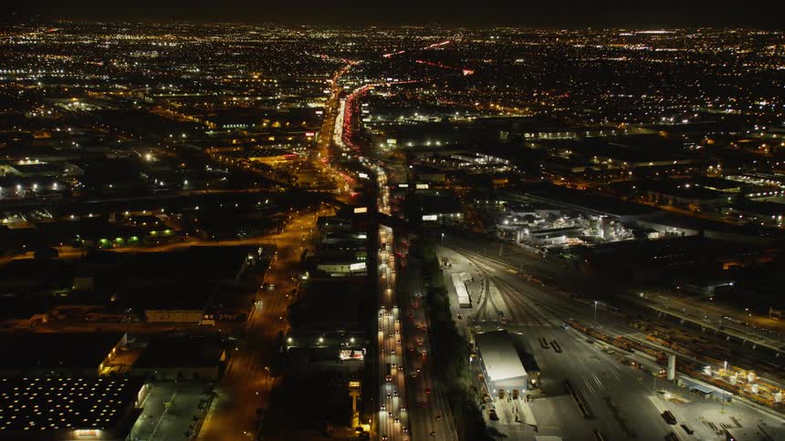 Cars drive on a city street at night