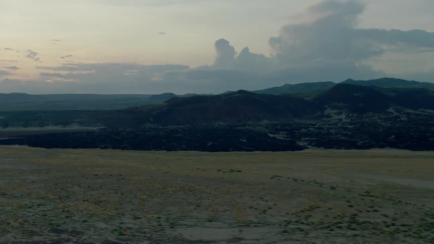 Clouds float above a mountain landscape at sunset