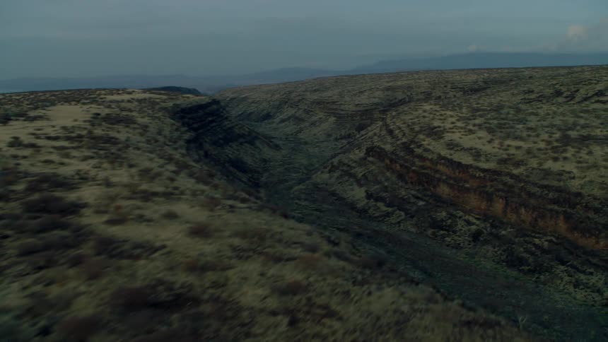 Ridges and valleys of a barren terrain on a cloudy day