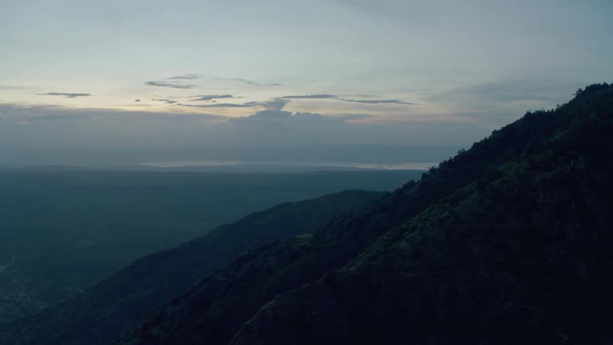 Green hills and the sunset on the horizon