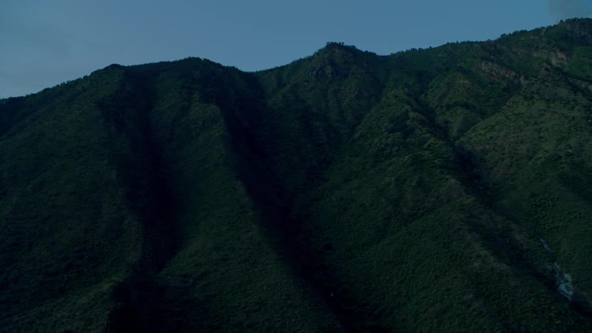 Darkness is hanging over a mountain ridge in the early morning