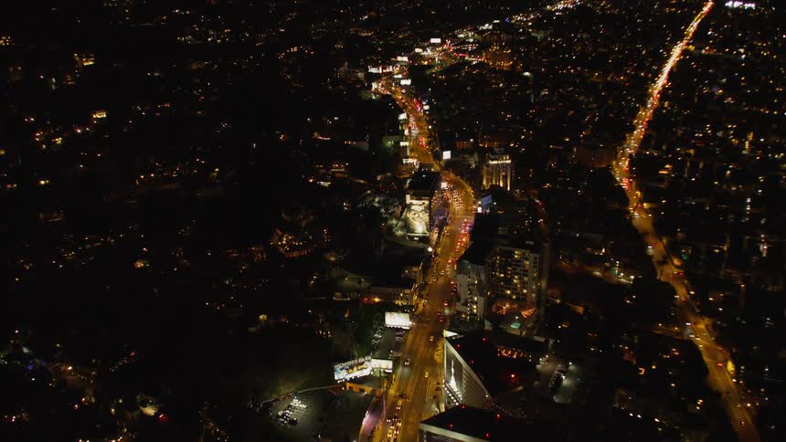 Vehicles travel on a city road at night