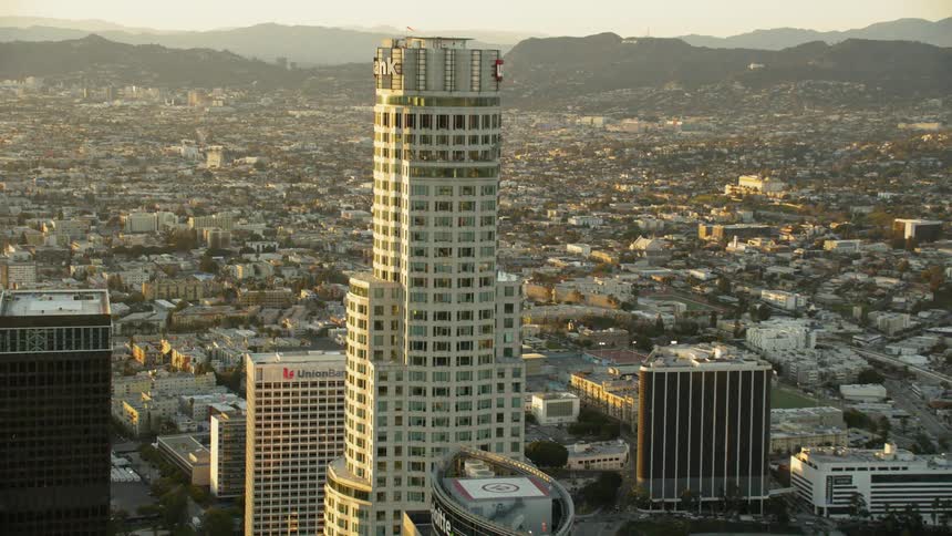 Skyscrapers stand in a city at sunset