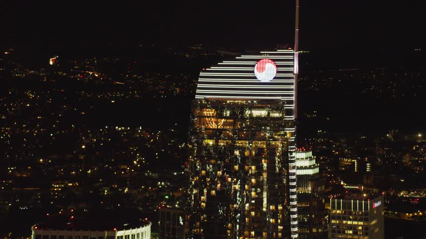 A tall city building is brightly illuminated