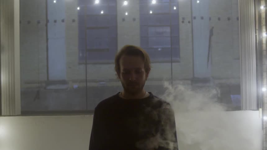 Smoke wafts around a white man