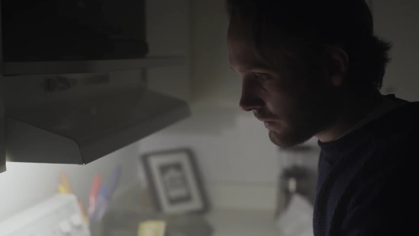 Depressed looking man staring at his oven light