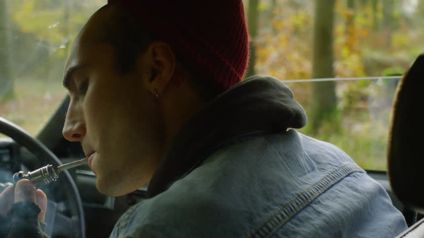 Man lights a cigarette in a car