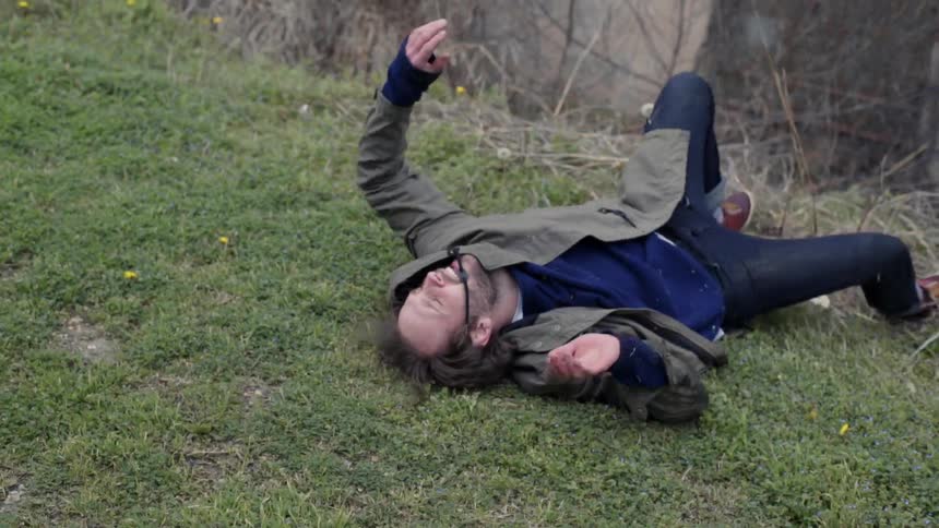 Man falls down and rolls on the grass