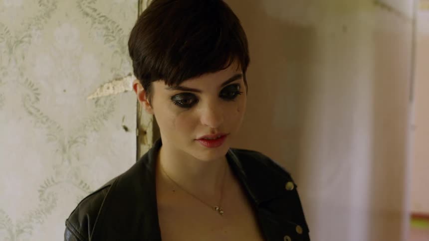 A woman leans against a doorway