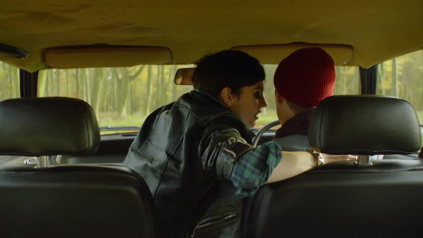 A woman starts to romantically move on a man driving a vehicle