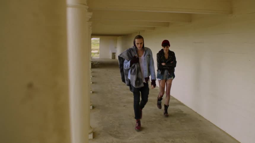 A man and woman walk next to a building