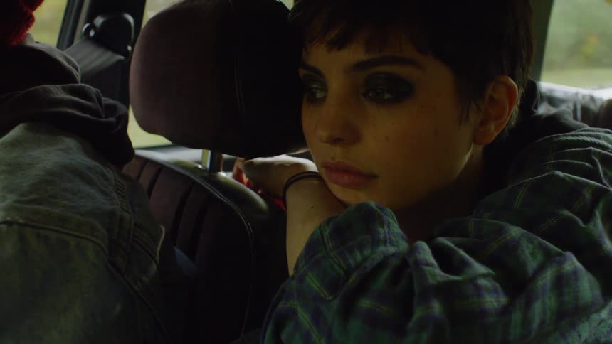 The girl leans over the driver's seat as someone drives