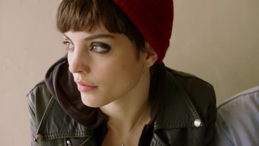 A woman looks sad while sitting indoors