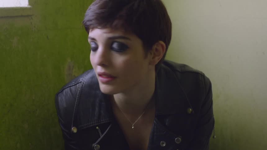 Woman sits in a room and looks out a window