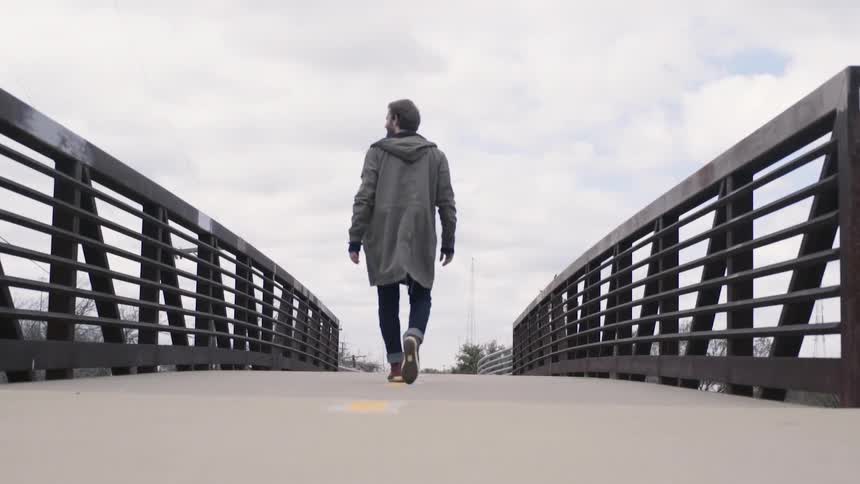 A man walking across a bridge