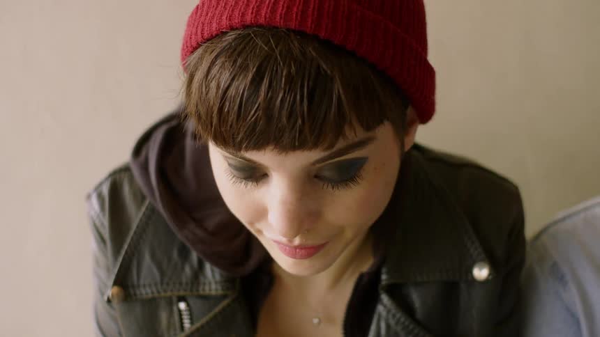 Woman wearing a toque looks down and then looks to the side