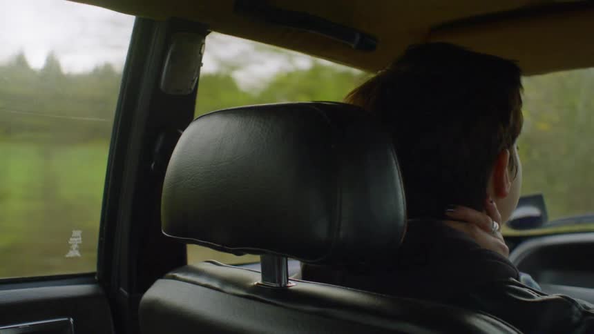 The girl looks to the side in the moving vehicle