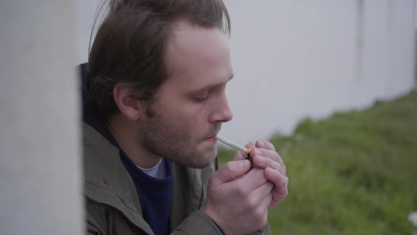 A man is lighting a smoke