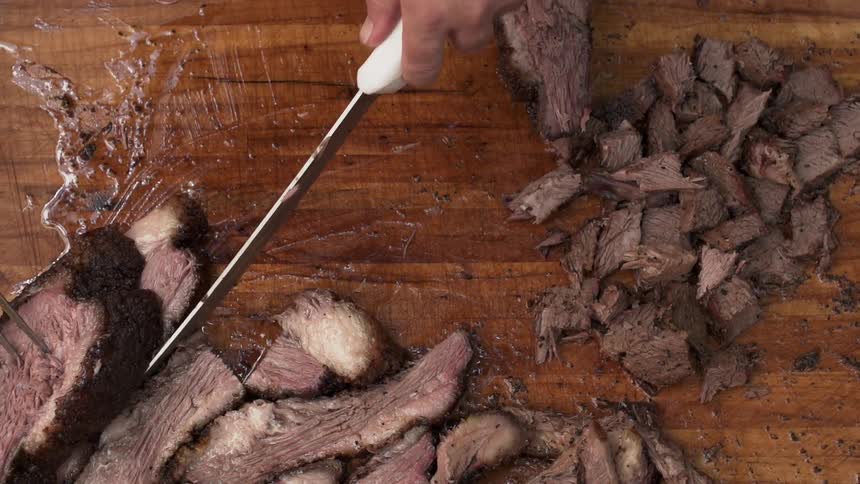 A person cuts up a grilled steak