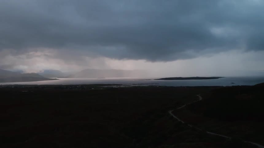 Storm clouds are hanging over a remote coast at dusk