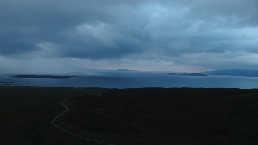 Storm clouds are hanging over a remote coast at dusk