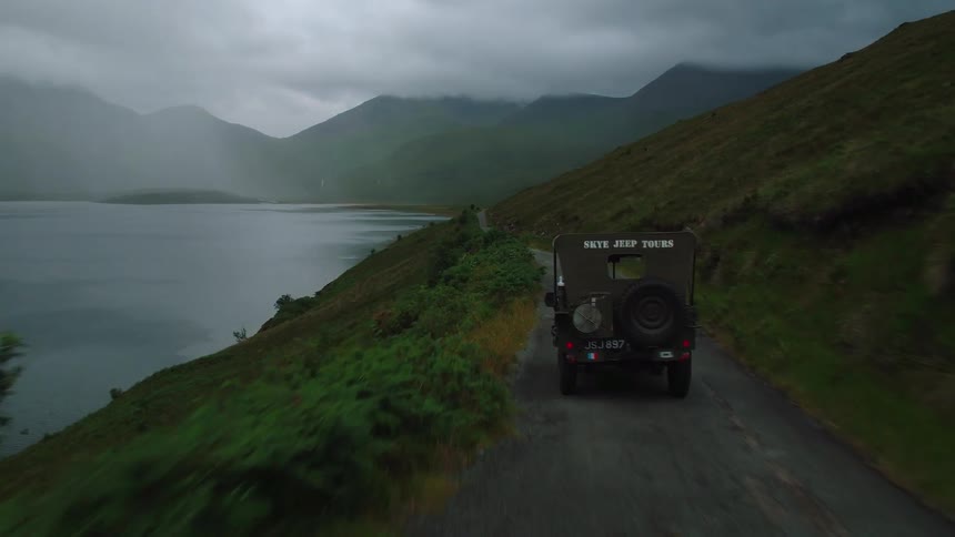 A truck drives down a lakeside road