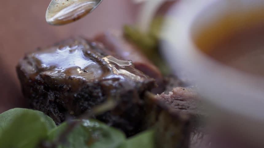 A sauce is poured onto beef