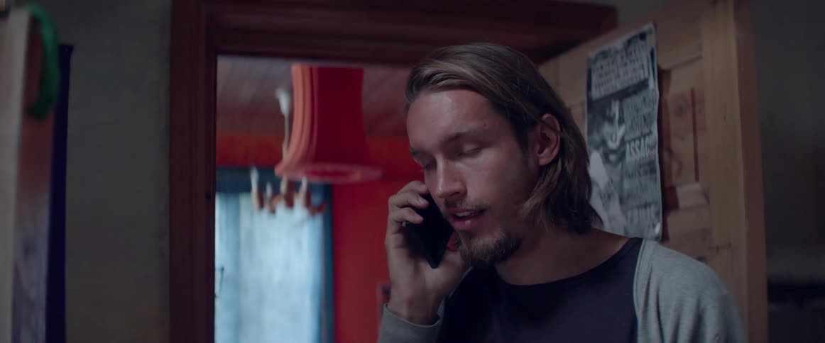 Profile view of a bearded guy having a quiet conversation on cell phone.