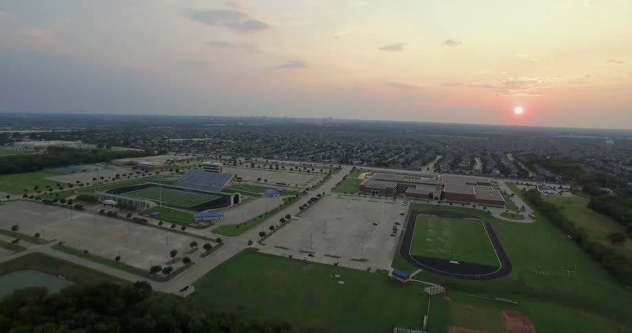 The sun sets over athletic fields