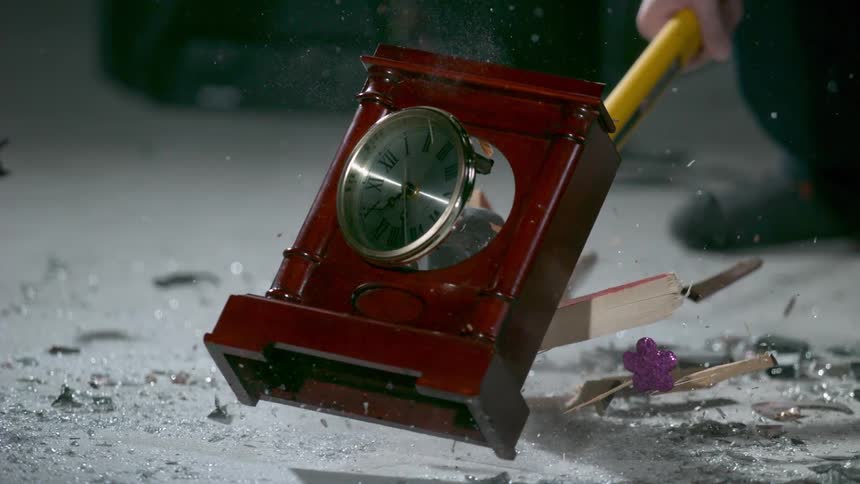 A man demolishes a clock with a sledgehammer